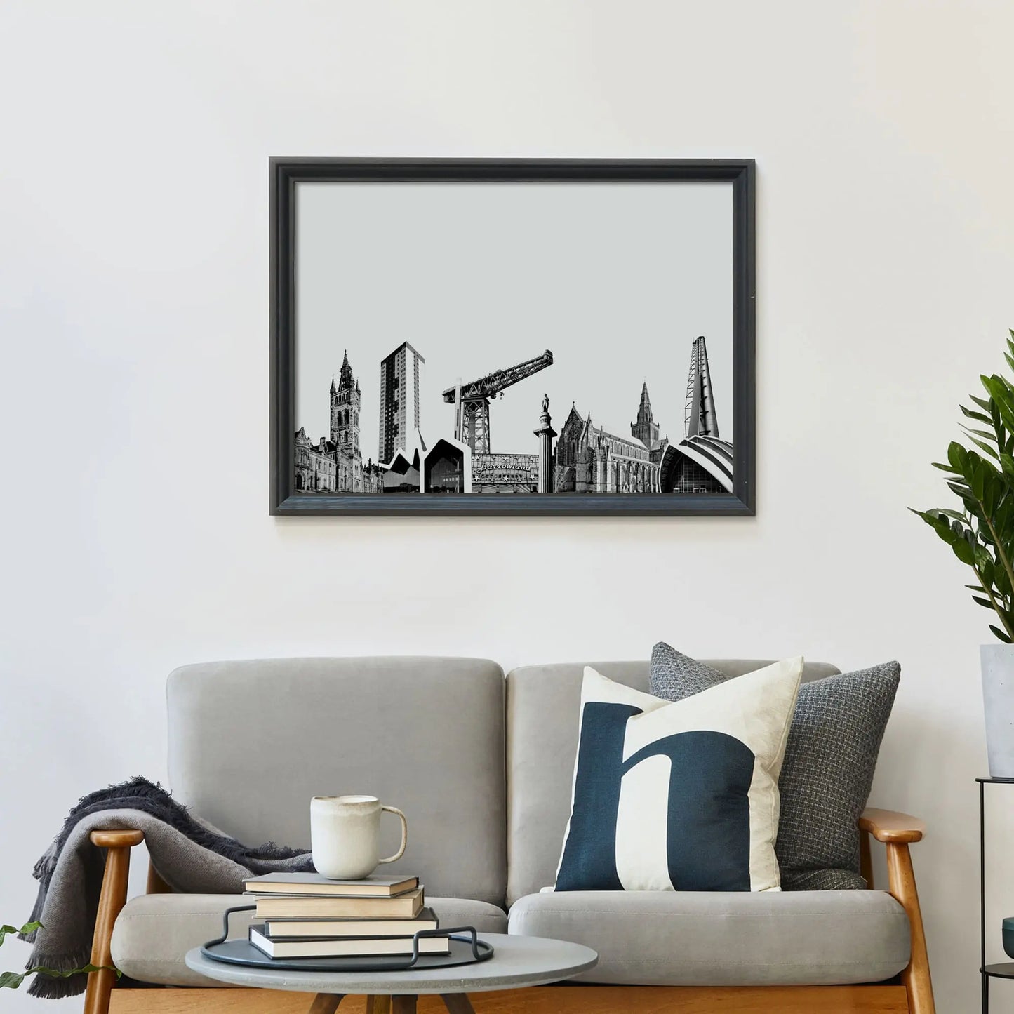 Glasgow art print on wall behind a modern room with a sofa and coffee table.